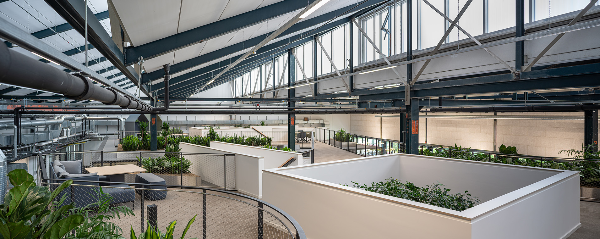 NOVA 10 in Neufahrn bei München – Revitalisierung einer ehemaligen Produktionshalle zu einer modernen, lebendigen Bürolandschaft durch Bottler_Lutz Architekten BDA, München. Das Projekt steht beispielhaft für hochwertiges Bauen im Bestand und zeigt die Transformation industrieller Architektur in flexible, zeitgemäße Arbeitsräume. Fotografie: Michael Heinrich.