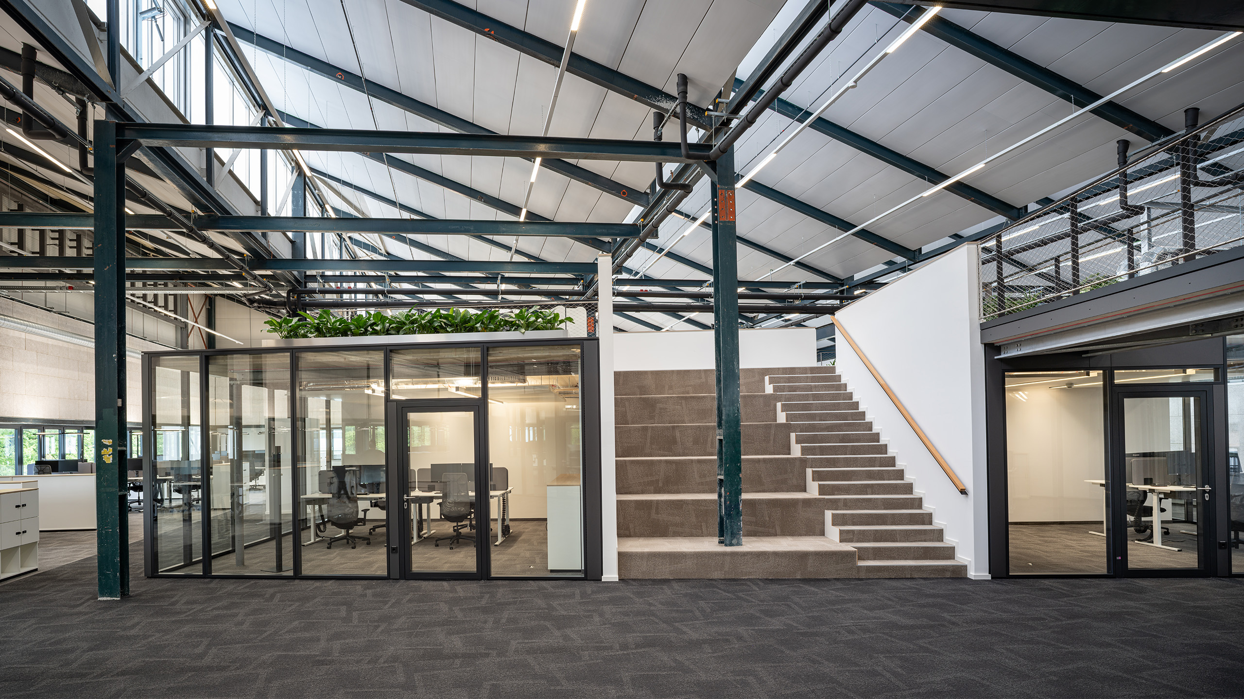 NOVA 10 in Neufahrn bei München – Revitalisierung einer ehemaligen Produktionshalle zu einer modernen, lebendigen Bürolandschaft durch Bottler_Lutz Architekten BDA, München. Das Projekt steht beispielhaft für hochwertiges Bauen im Bestand und zeigt die Transformation industrieller Architektur in flexible, zeitgemäße Arbeitsräume. Fotografie: Michael Heinrich.